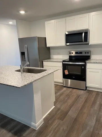 a kitchen with granite countertop a stove and a microwave