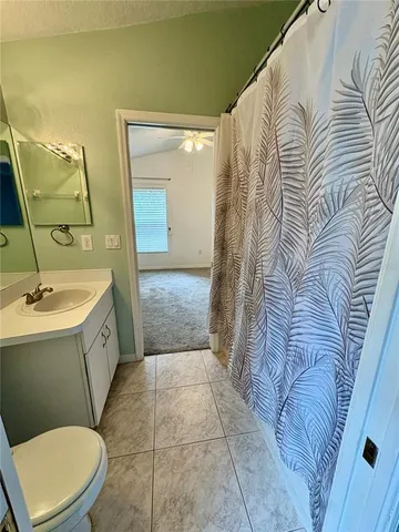 a spacious bathroom with a granite countertop sink a toilet a mirror and bathtub