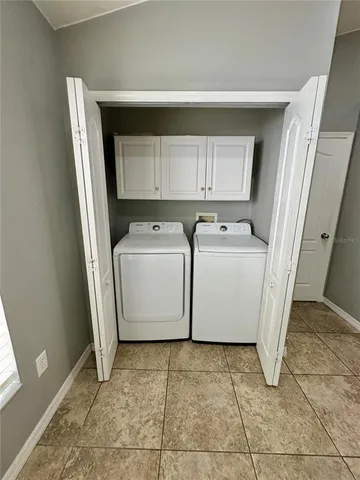 a utility room with cabinets washer and dryer
