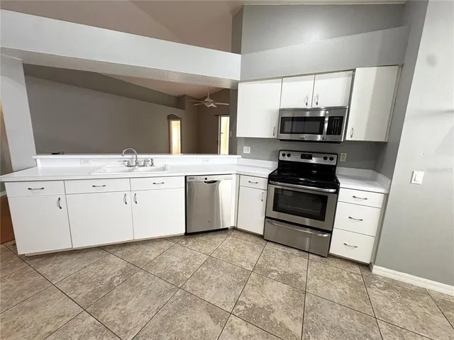 a kitchen with stainless steel appliances a stove microwave and white cabinets