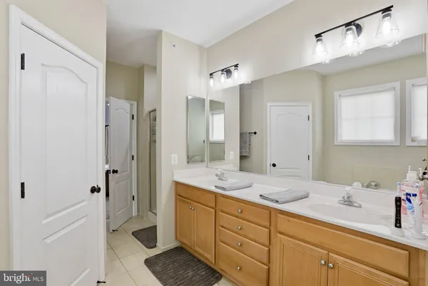 a spacious bathroom with a shower sink and mirror