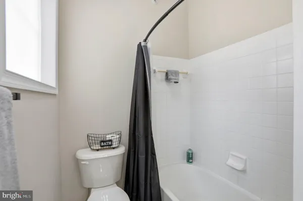 a white toilet sitting next to a white bath tub