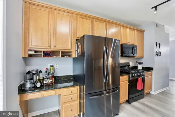 a kitchen with stainless steel appliances granite countertop a refrigerator and a stove top oven