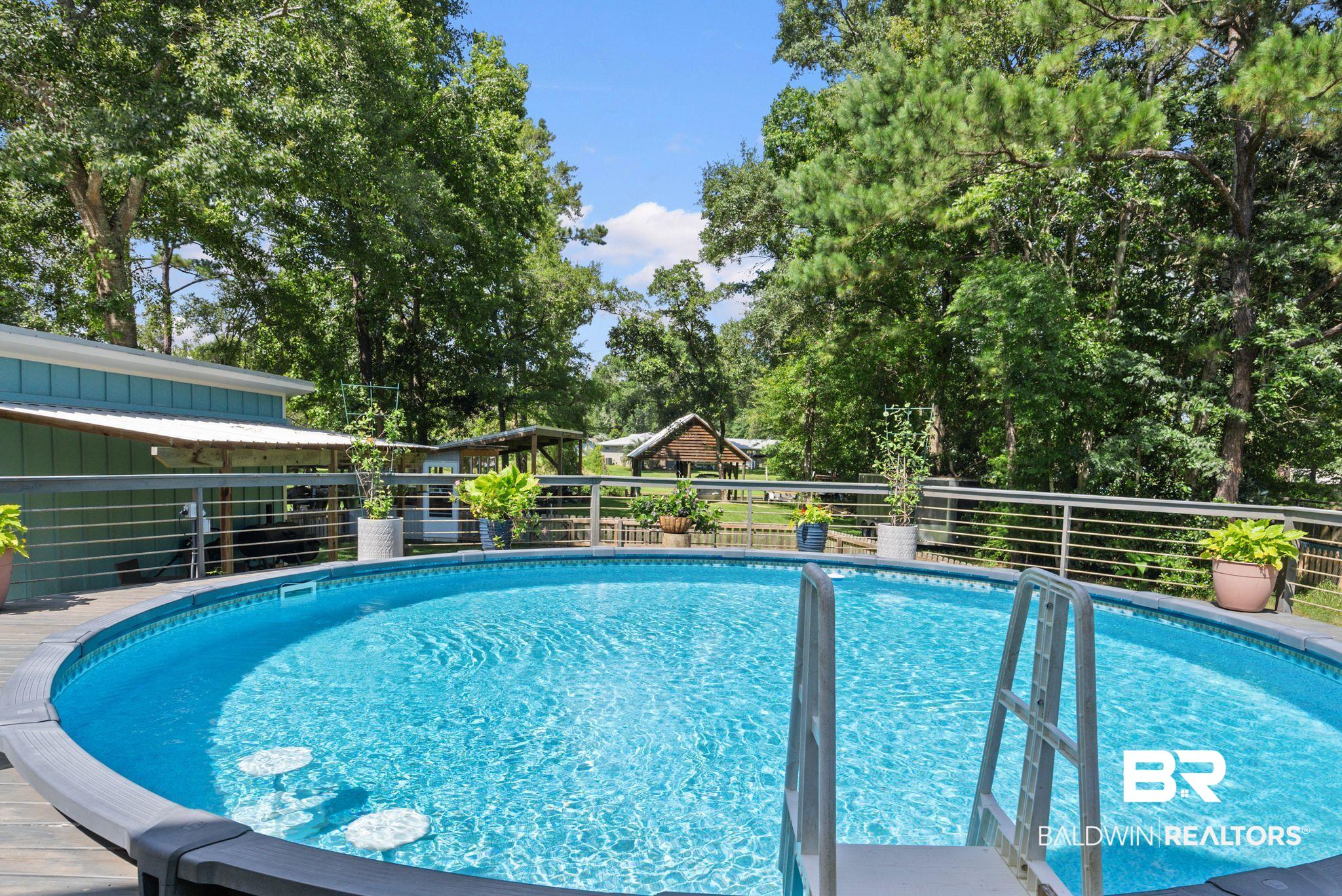 7266 Franklin Road Foley, AL 36535 - Photo 58 of 64 Above-ground pool with integrated steps and submerged seating, surrounded by a wood-finish deck