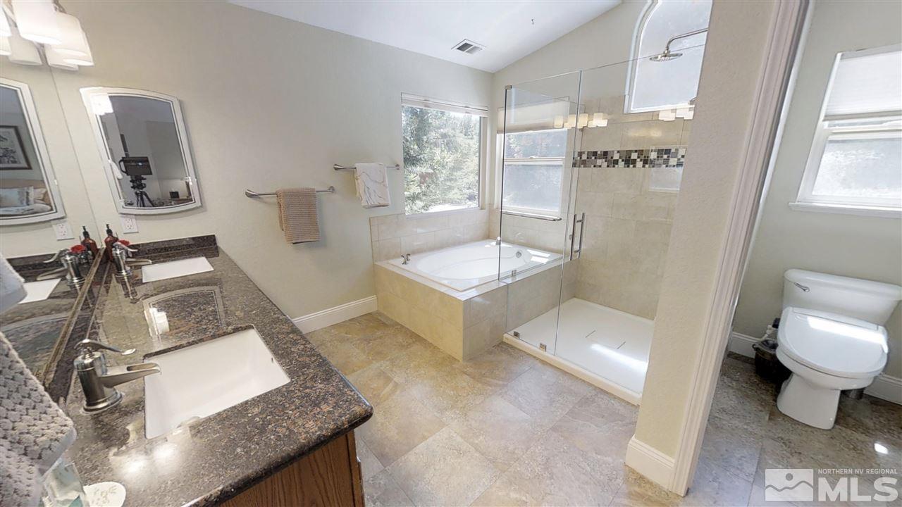 1970 Honey Ridge Drive Reno, NV 89511 - Photo 14 of 25 a bathroom with a granite countertop sink a toilet a mirror and shower