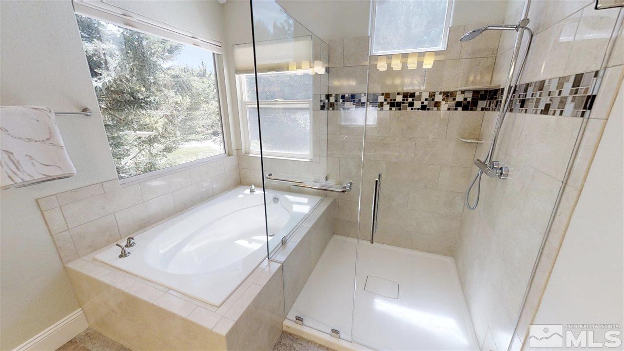1970 Honey Ridge Drive Reno, NV 89511 - Photo 15 of 25 a bathroom with a tub a sink and a large mirror
