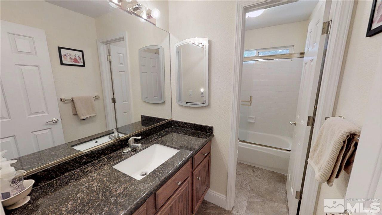 1970 Honey Ridge Drive Reno, NV 89511 - Photo 19 of 25 a bathroom with a granite countertop sink a mirror and a shower