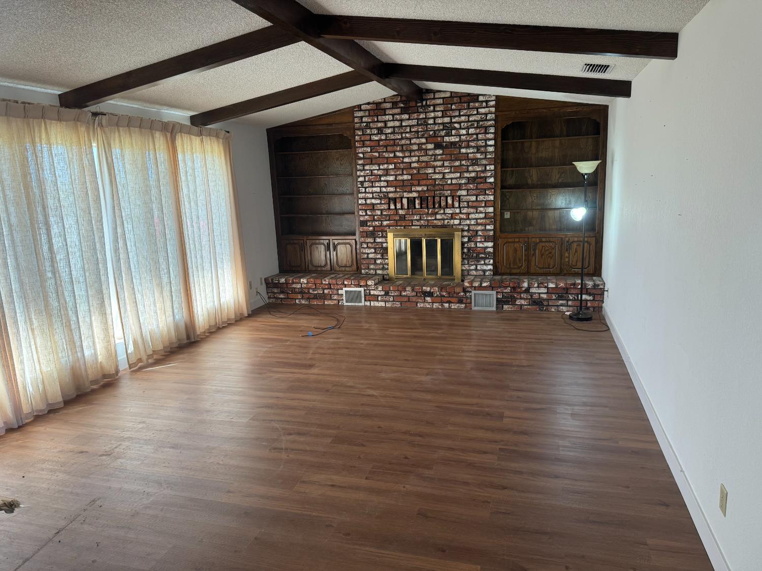 376 East Klepper Avenue Caruthers, CA 93609 - Photo 13 of 13 an empty room with wooden floor and windows