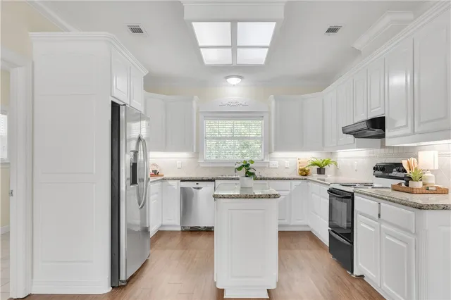 a kitchen with a sink cabinets and window