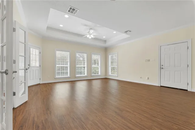 a view of an empty room with wooden floor