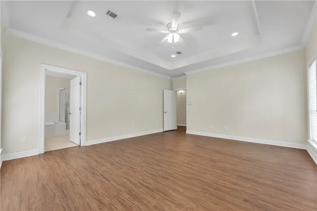 a view of an empty room with wooden floor