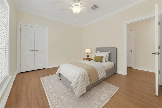 a bedroom with a bed and wooden floor