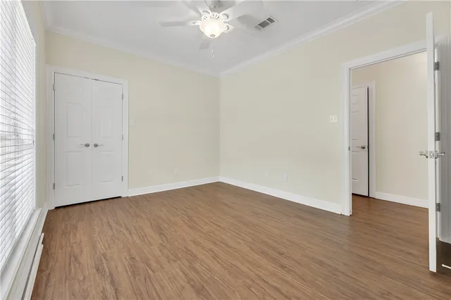 a view of an empty room with wooden floor