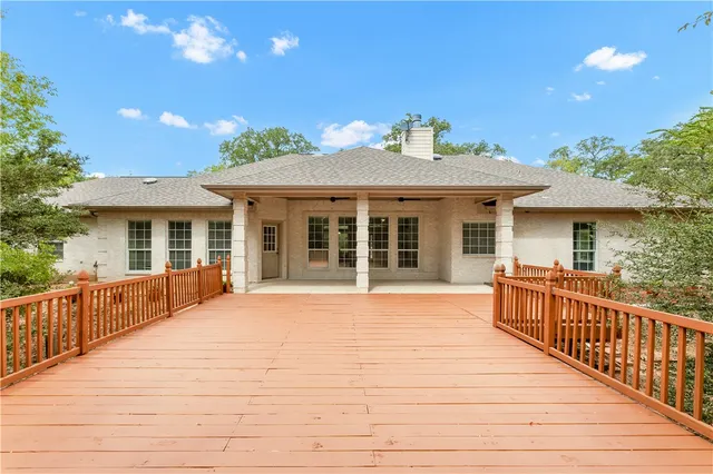 a view of a house with wooden deck and furniture