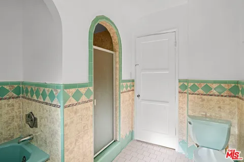 a bathroom with a granite countertop shower a mirror and a sink