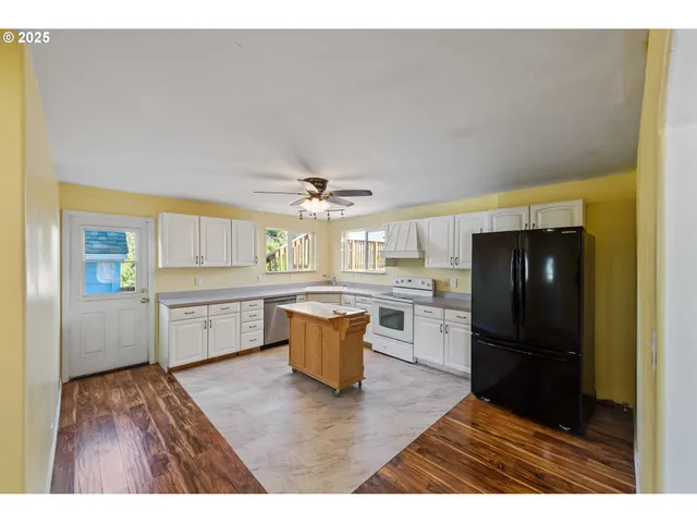 a kitchen with a refrigerator and wooden cabinets