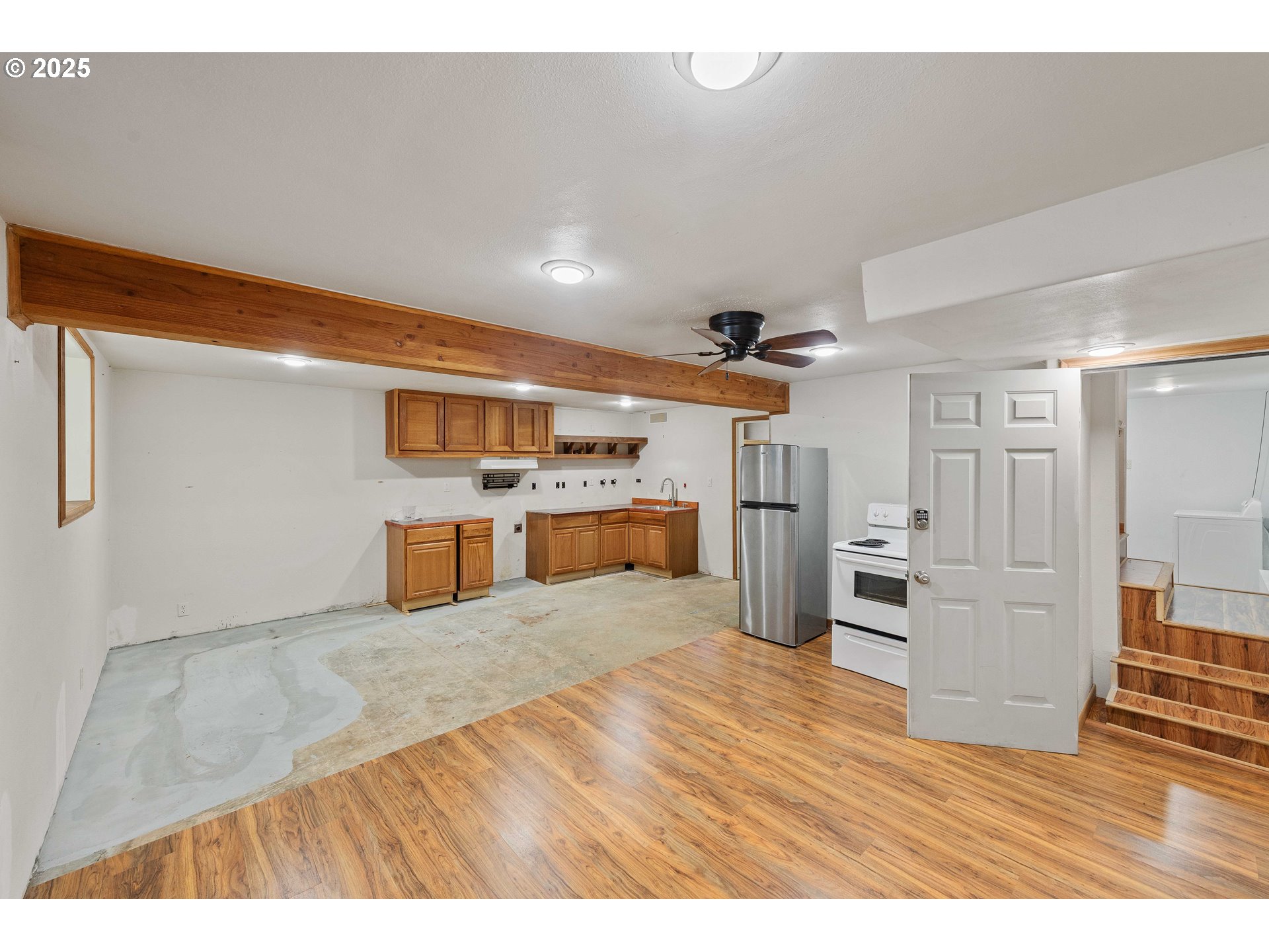 584 Exchange Street North Bend, OR 97459 - Photo 25 of 48 a kitchen with stainless steel appliances kitchen island wooden floors and white cabinets