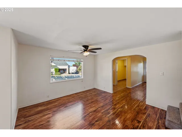 a view of empty room with window and ceiling fan
