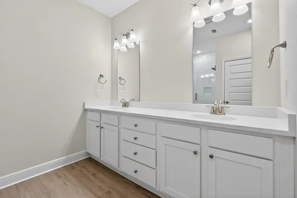 a bathroom with double vanity sink and a mirror