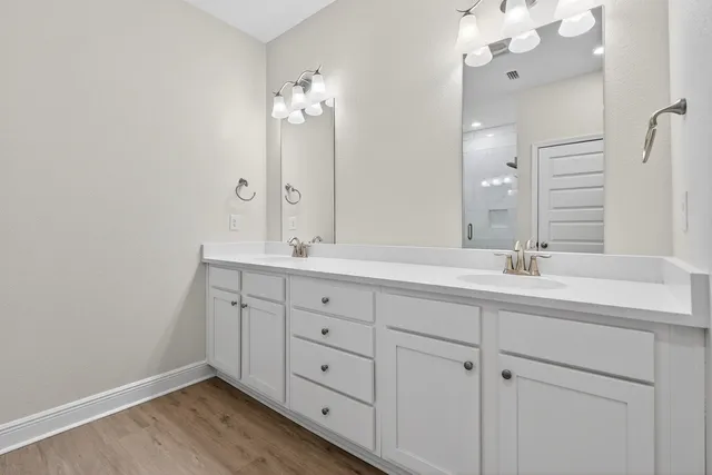 a bathroom with double vanity sink and a mirror