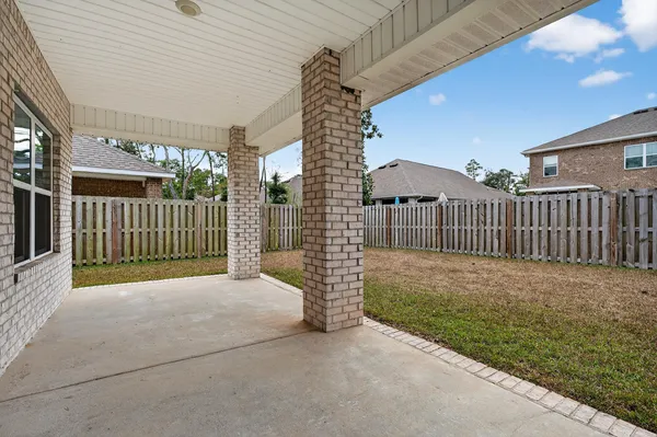 a view of a porch with a small yard and wooden fence