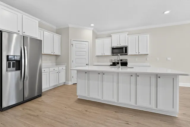 a kitchen with white cabinets white stainless steel appliances and sink