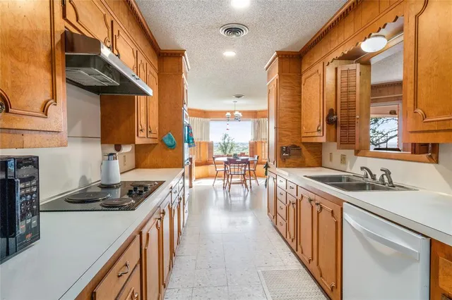 a kitchen with stainless steel appliances a stove a sink and cabinets