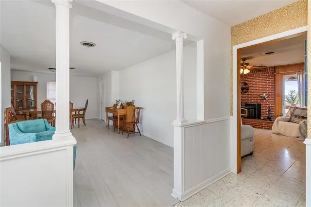 a living room with furniture and a refrigerator