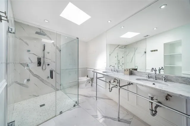 a bathroom with a double vanity sink mirror and shower