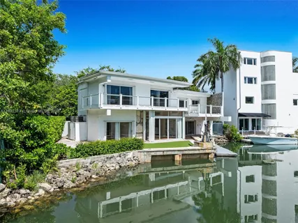 a front view of a building with lake view and trees