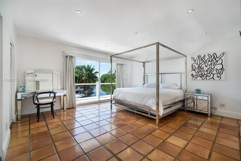 a bedroom with a bed and a view of balcony