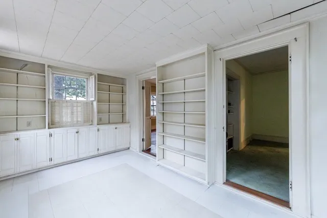 an empty room with cabinet and windows