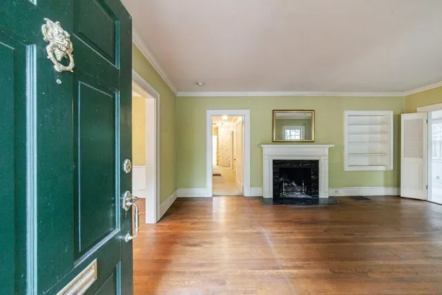 a view of an empty room with glass door and wooden floor