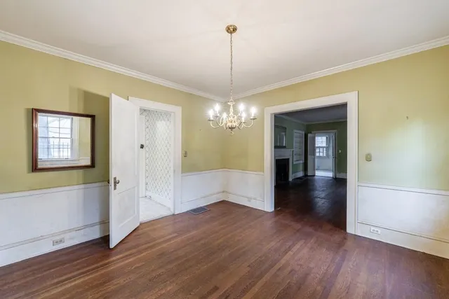 a view of a hallway with wooden floor and a chandelier