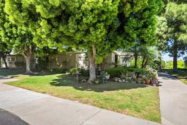 a backyard of a house with table and chairs plants and trees
