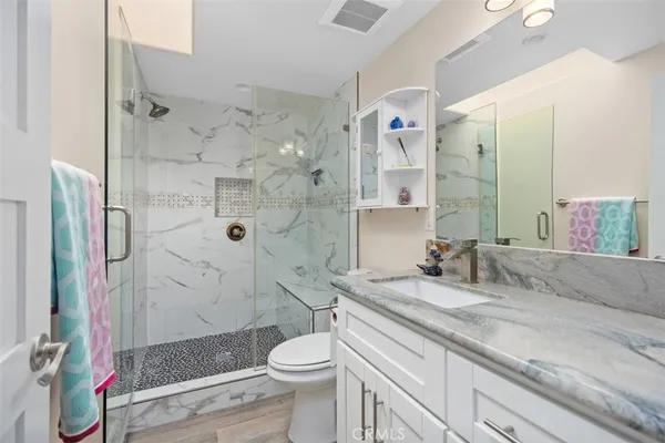 a bathroom with a granite countertop sink toilet and shower