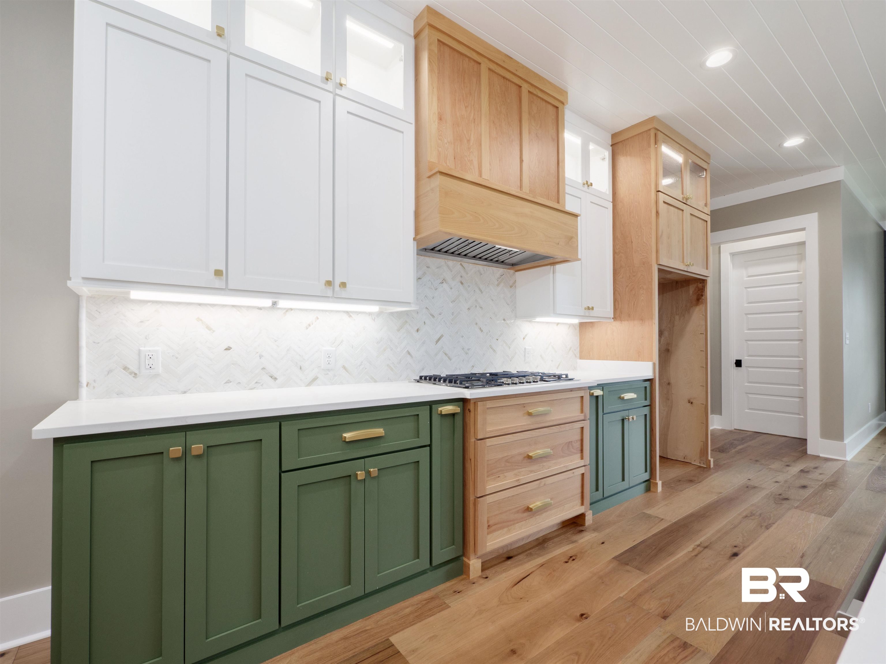 10970 Turin Avenue Fairhope, AL 36532 - Photo 9 of 61 Kitchen featuring green cabinets, glass insert cabinets, tasteful backsplash, white cabinetry, and light wood-type flooring