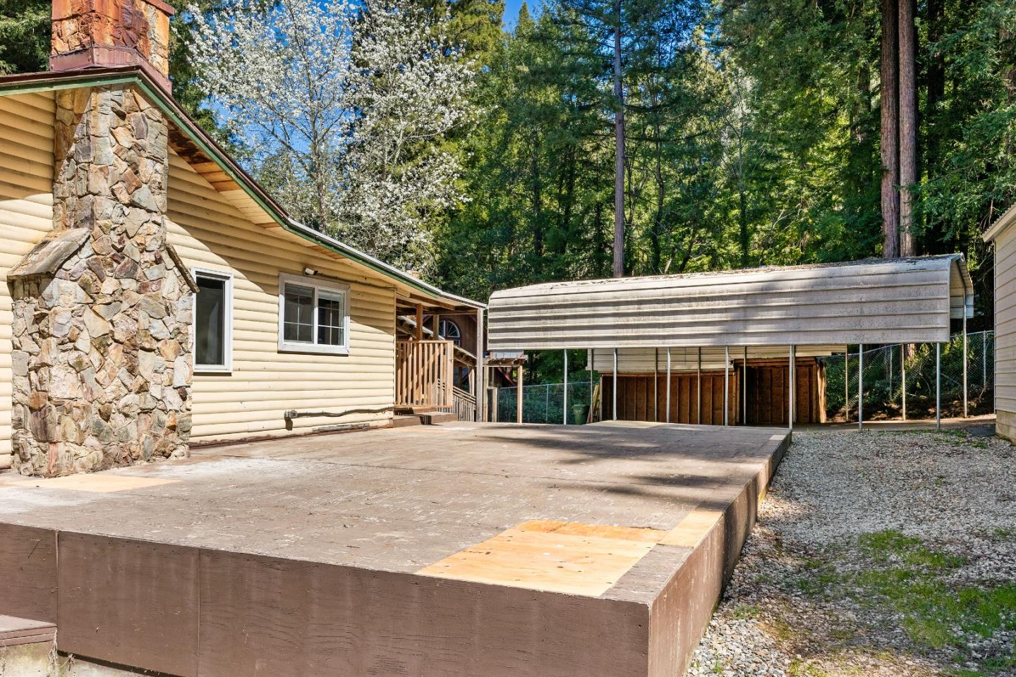 15666 Kings Creek Road Boulder Creek, CA 95006 - Photo 31 of 40 a backyard of a house with large trees and wooden fence