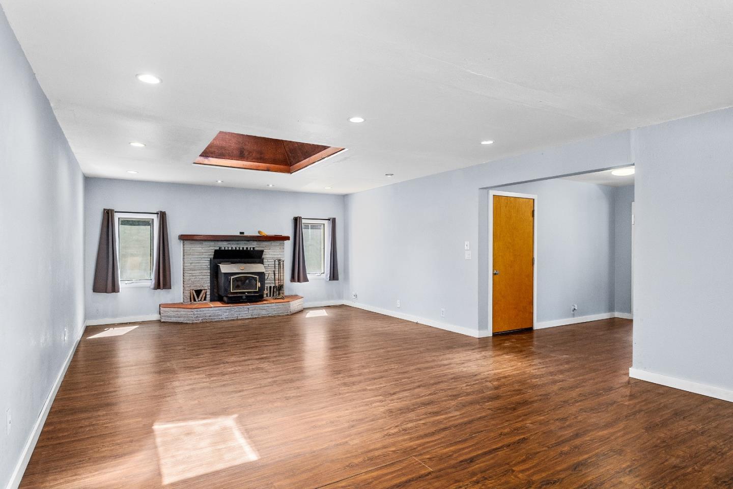 15666 Kings Creek Road Boulder Creek, CA 95006 - Photo 6 of 40 a view of empty room with wooden floor and fireplace