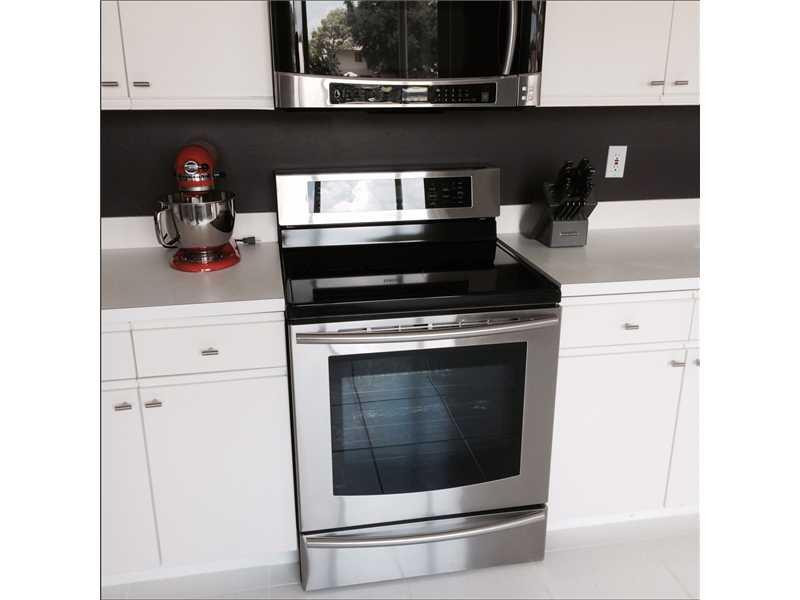 10096 Country Brook Road Boca Raton, FL 33428 - Photo 3 of 29 a kitchen with a stove and cabinets