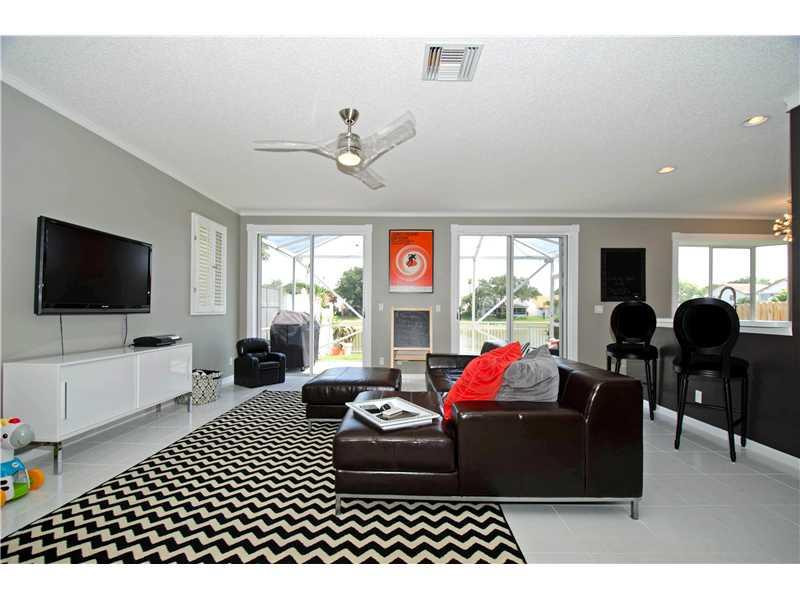 10096 Country Brook Road Boca Raton, FL 33428 - Photo 6 of 29 a living room with furniture a flat screen tv and a large window