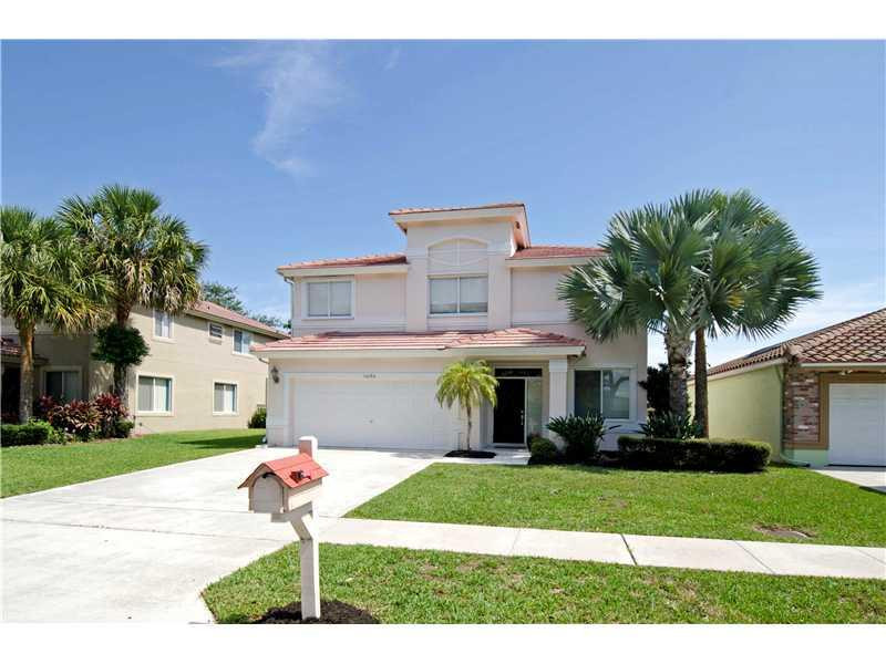 10096 Country Brook Road Boca Raton, FL 33428 - Photo 7 of 29 a front view of a house with a garden and yard