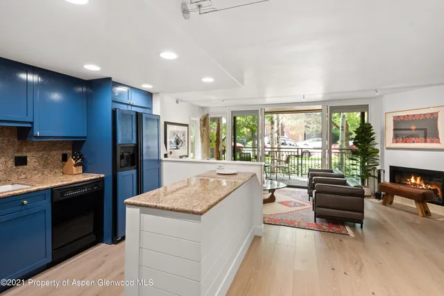 a living room with stainless steel appliances granite countertop furniture a refrigerator a couch and a kitchen view