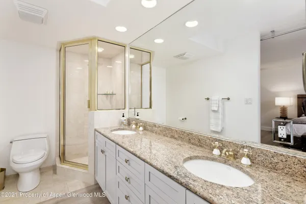 a bathroom with a granite countertop sink toilet and shower