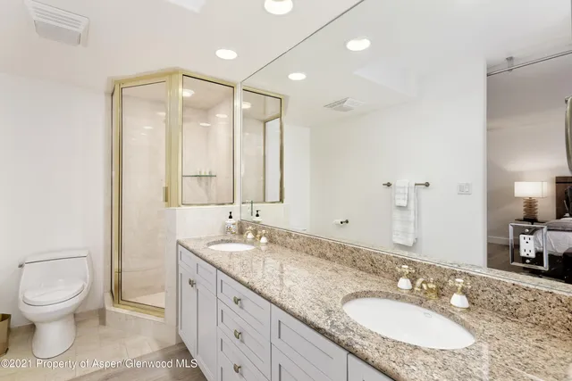 a bathroom with a granite countertop sink toilet and shower