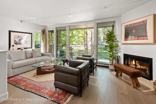 a living room with furniture a large window and a fireplace