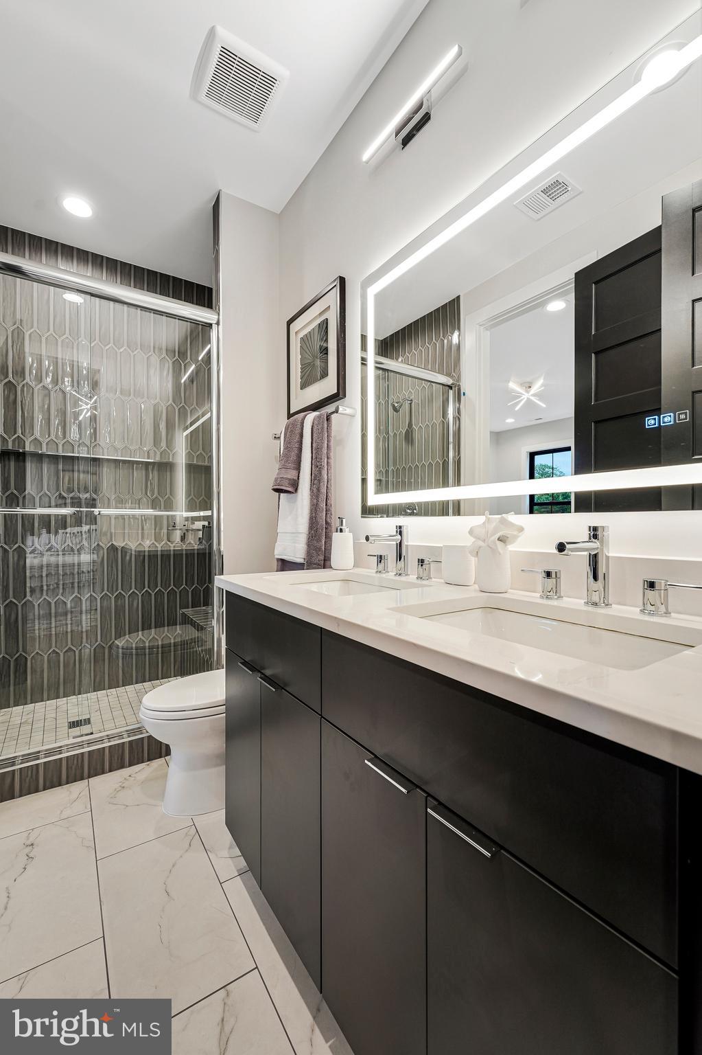 11410 Waples Mill Road Oakton, VA 22124 - Photo 24 of 104 a bathroom with a double vanity sink a mirror and shower