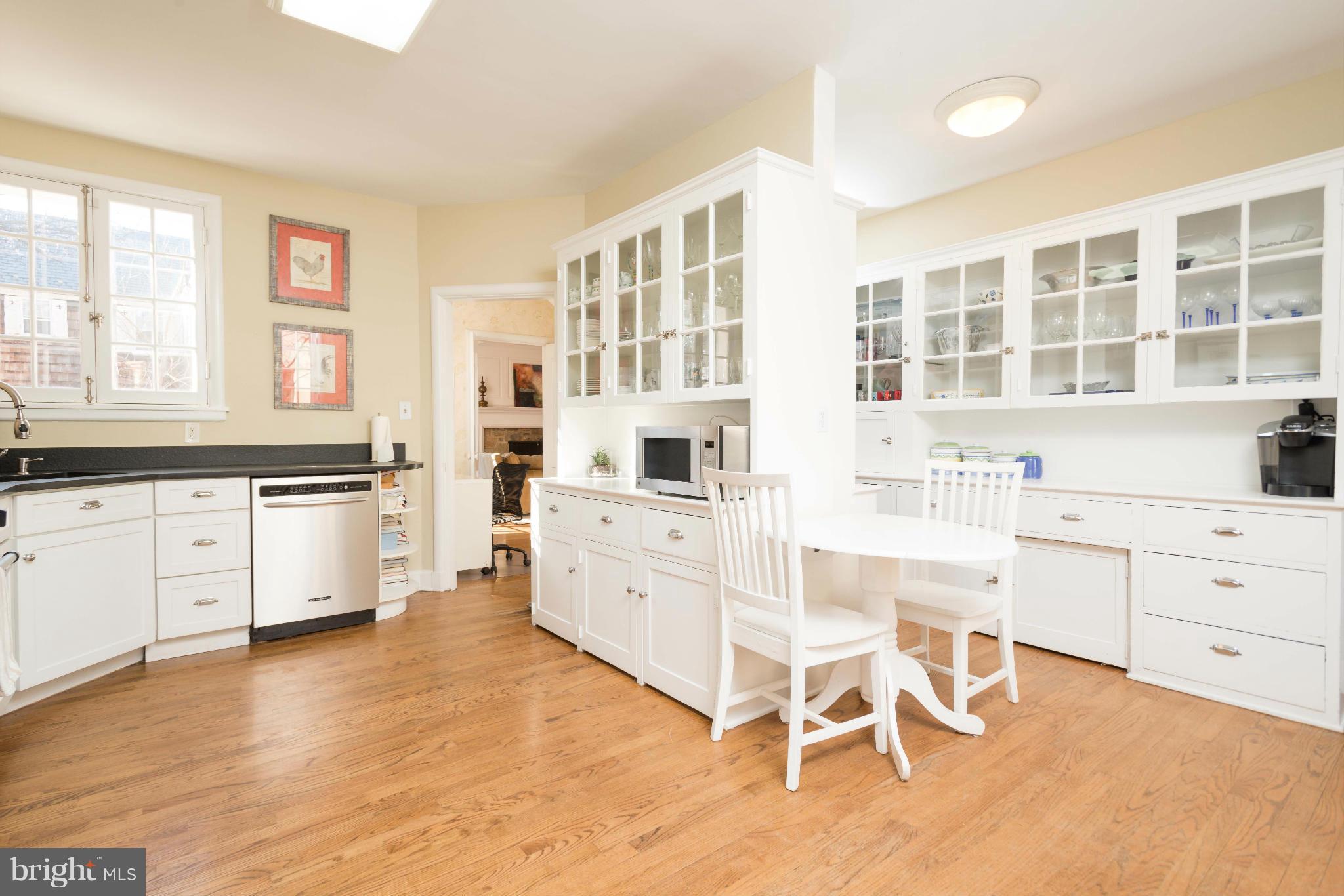 207 Witherspoon Road Baltimore, MD 21212 - Photo 10 of 28 a kitchen with white cabinets and wooden floor