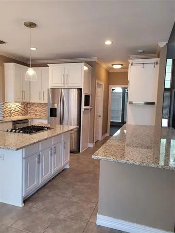 a view of an empty room with a kitchen