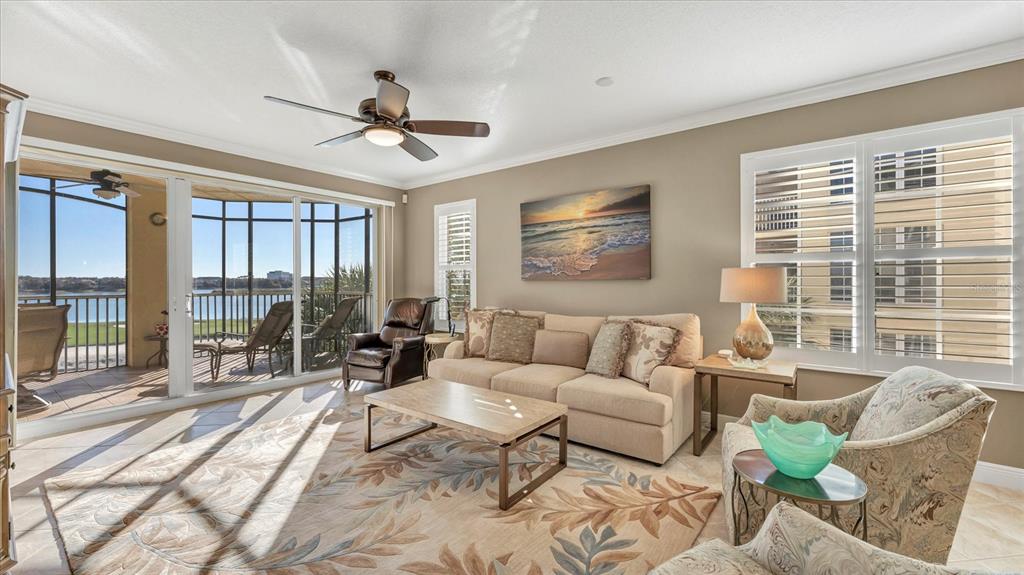6414 Water Crest Way, Unit 302 Lakewood Ranch, FL 34202 - Photo 12 of 74 a living room with furniture and floor to ceiling windows